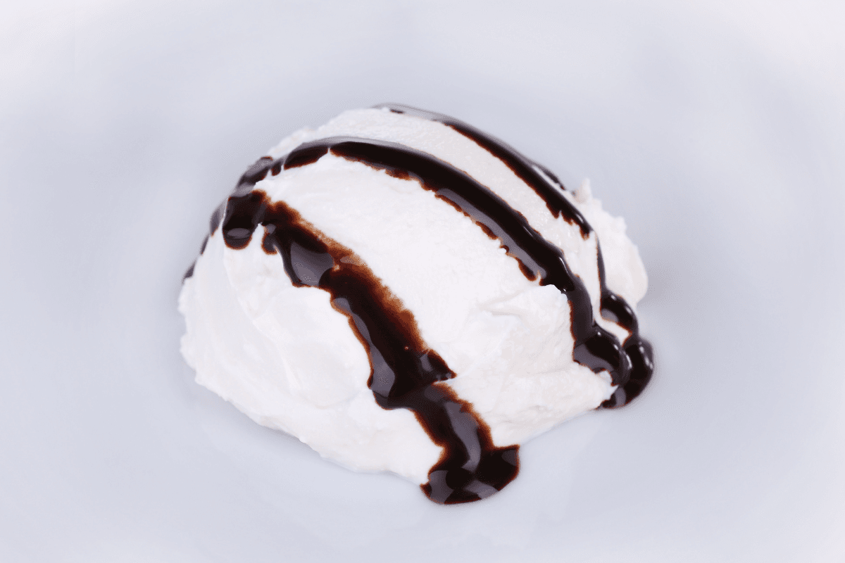 Lody o smaku waniliowym w kubeczku z polewą o smaku czekoladowym