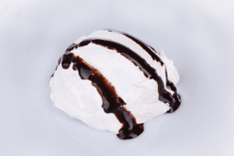 Lody o smaku waniliowym w kubeczku z polewą o smaku czekoladowym